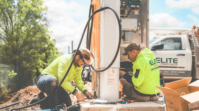 Two electricians working on electrical equipment installation outdoors in Tomago, NSW, Australia.